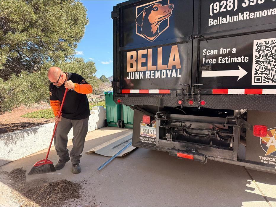Robert sweeping up after a junk removal job in Sedona. Every job ends with a clean site.