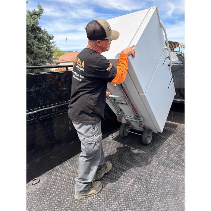 Bella Junk Removal crew member securing a refrigerator inside the dump truck during a refrigerator removal job.