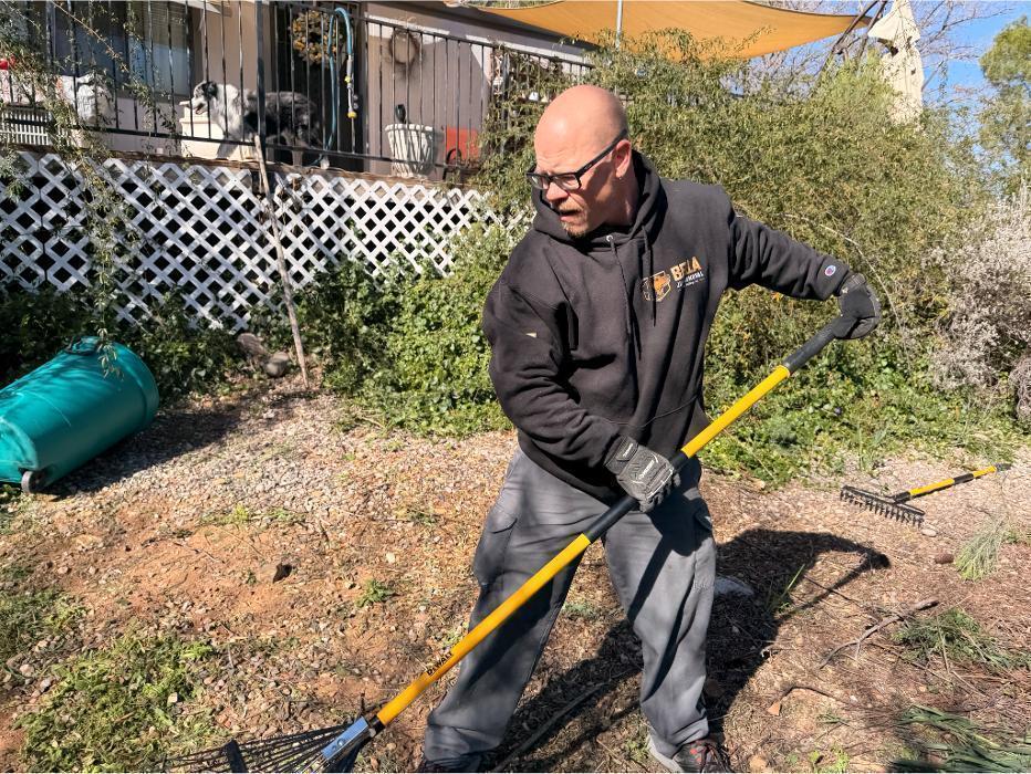 Robert raking up leaves during a yard debris removal job in the Verde Valley.
