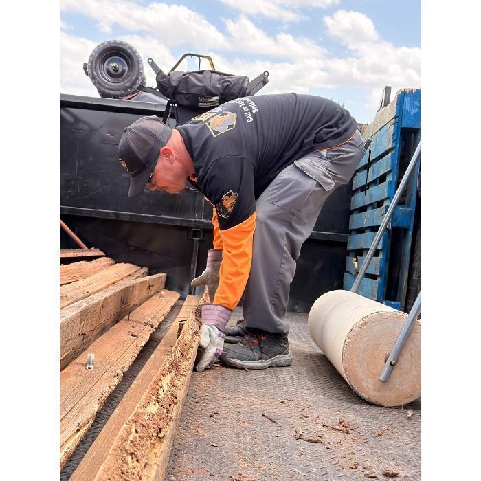 Robert stacking lumber in the dump truck.