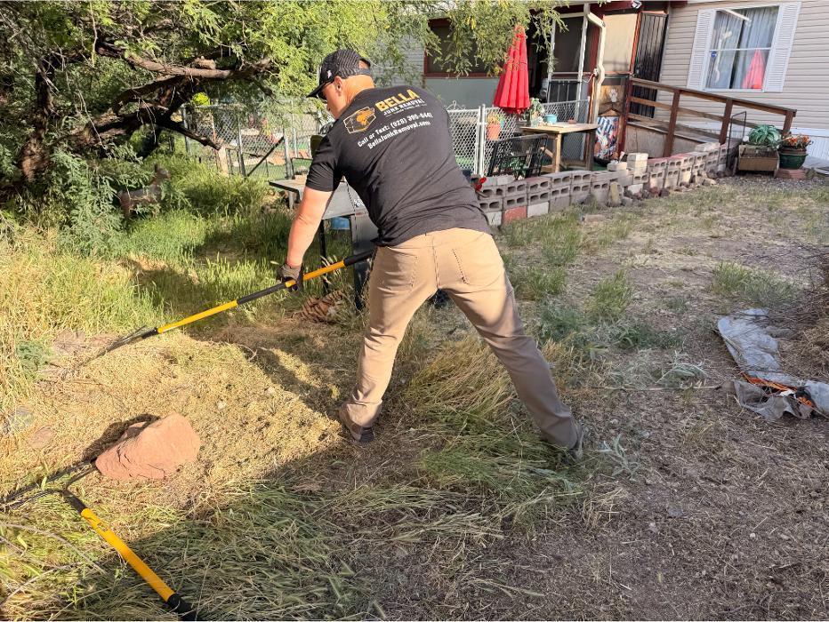 Bella Junk Removal owner raking yard debris during a yard cleanup job.