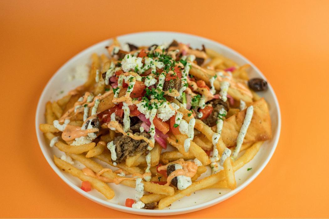 The Zeus at Santorini's Farmington: Fries topped with gyro meat, feta, and Doner Aioli. A Best of State favorite at Farmington Station!