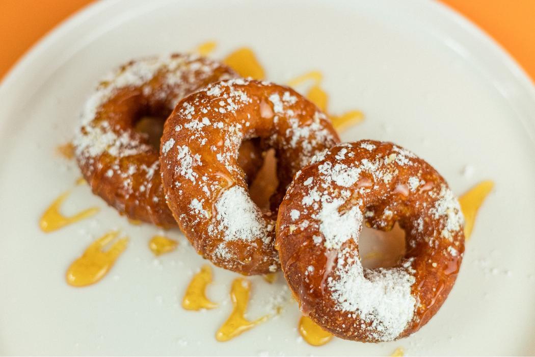 Loukoumades at Santorini's Farmington: Golden fried Greek donuts with powdered sugar and honey. The perfect treat at Farmington Station!
