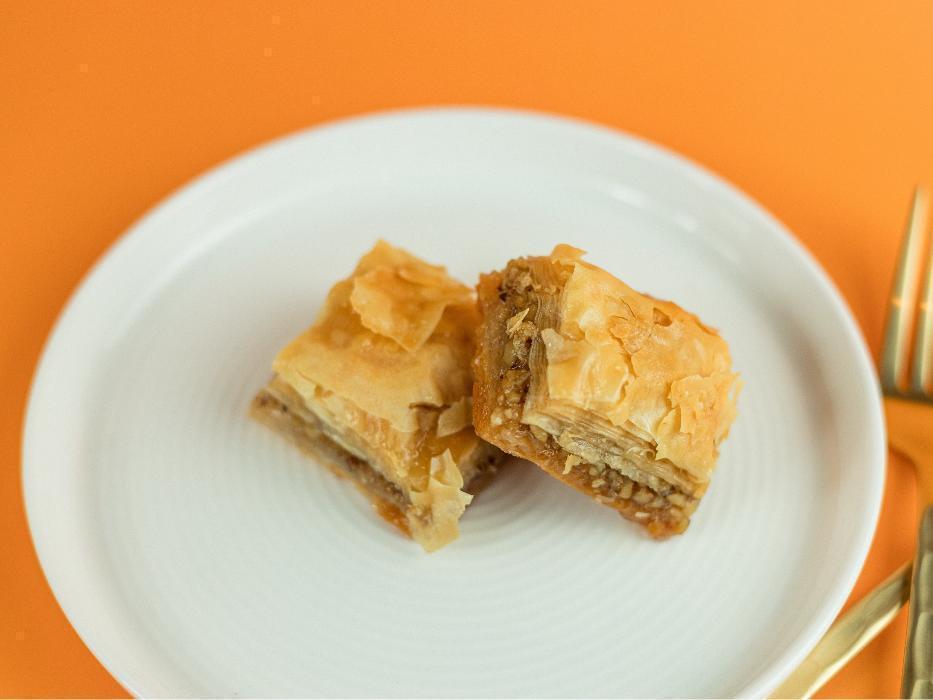 Baklava at Santorini’s West Bountiful: Flaky phyllo pastry layers filled with chopped nuts and honey. A classic sweet Greek treat!