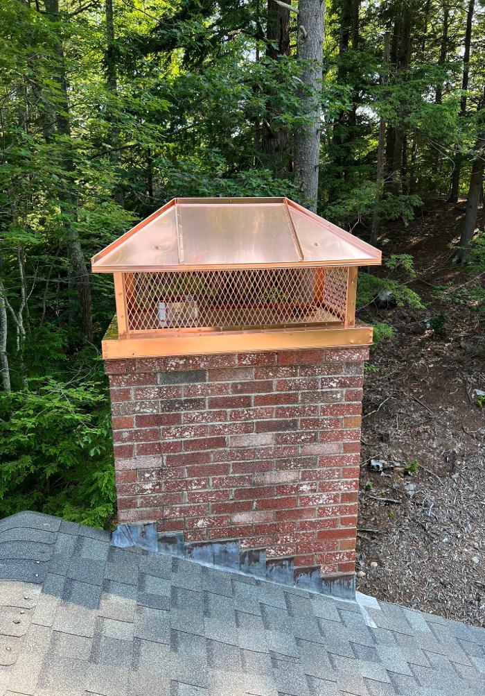 Custom copper chimney cap installed on a brick chimney in Biddeford, ME 