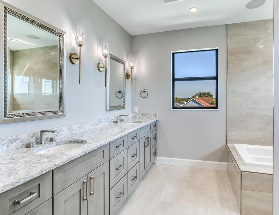 Spacious contemporary bathroom with a double vanity, large mirror, walk-in shower, and soft gray and white finishes.