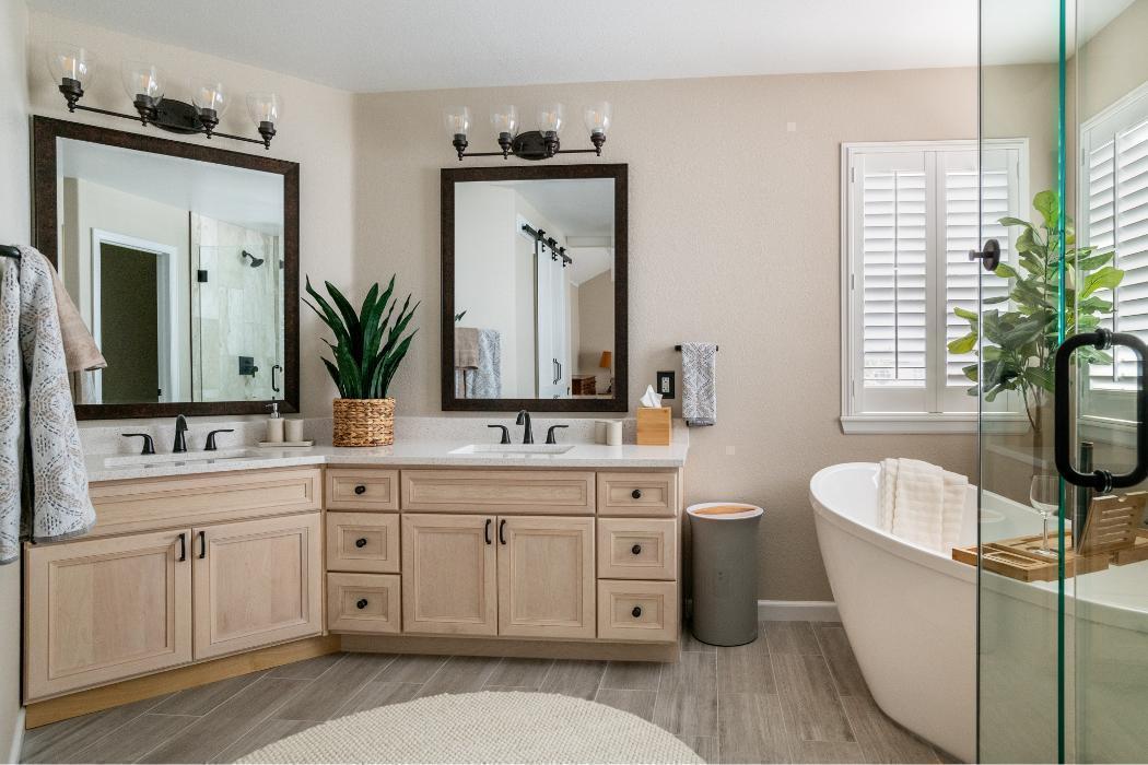 Warm Natural Wood Transitional Master Bathroom
A welcoming, warmly styled master bathroom with a natural, organic feel. The angled double vanity features light natural maple/blonde wood raised-panel cabinetry