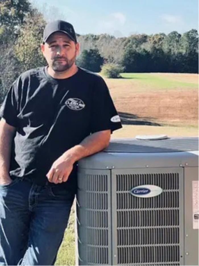 Jay Lovett, owner of Clean Air Solutions, standing beside a Carrier HVAC unit while providing heating and air conditioning services in Oxford, Mississippi