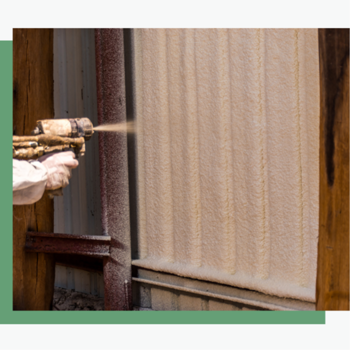 Attic insulation installation in progress: skilled workers using spray foam application tools to insulate the underside of the roof deck, preventing air leaks and heat loss.
