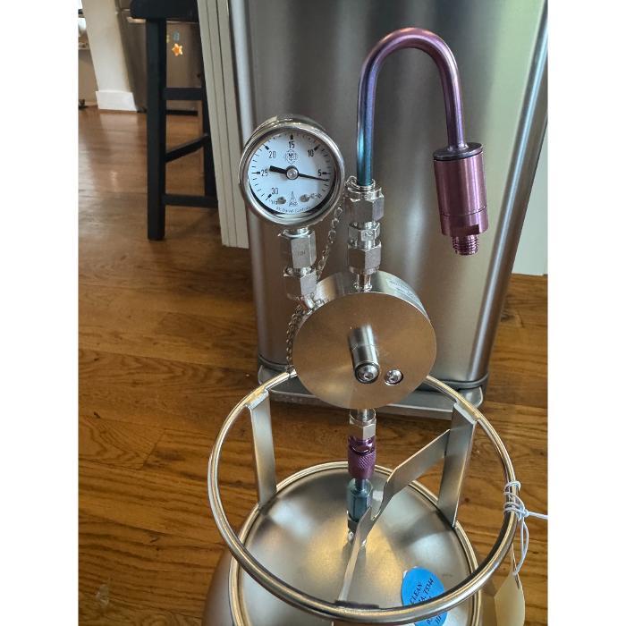 A piece of specialized drying or restoration equipment with gauges and tubing, positioned on a wood floor indoors.