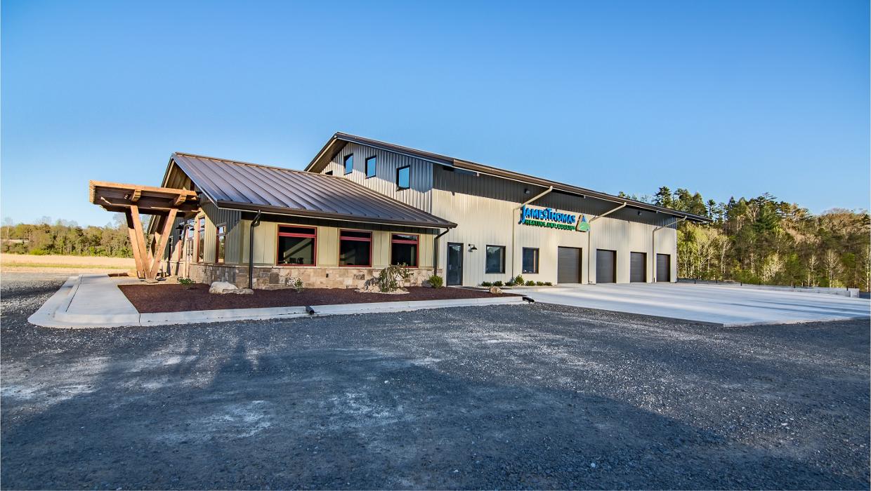 Modern commercial building exterior with a freshly paved parking lot under a clear blue sky.