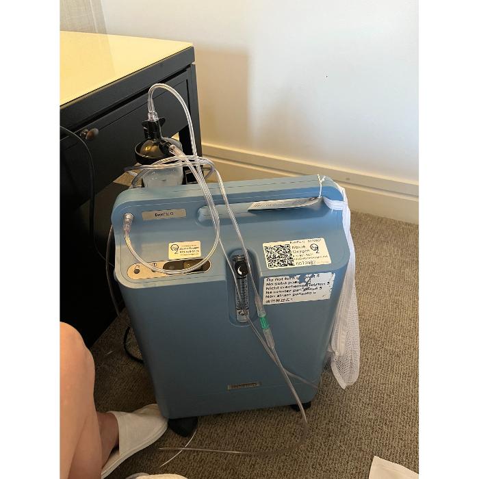 A portable oxygen concentrator with tubing and controls visible, highlighting the medical-grade equipment available for rent.
