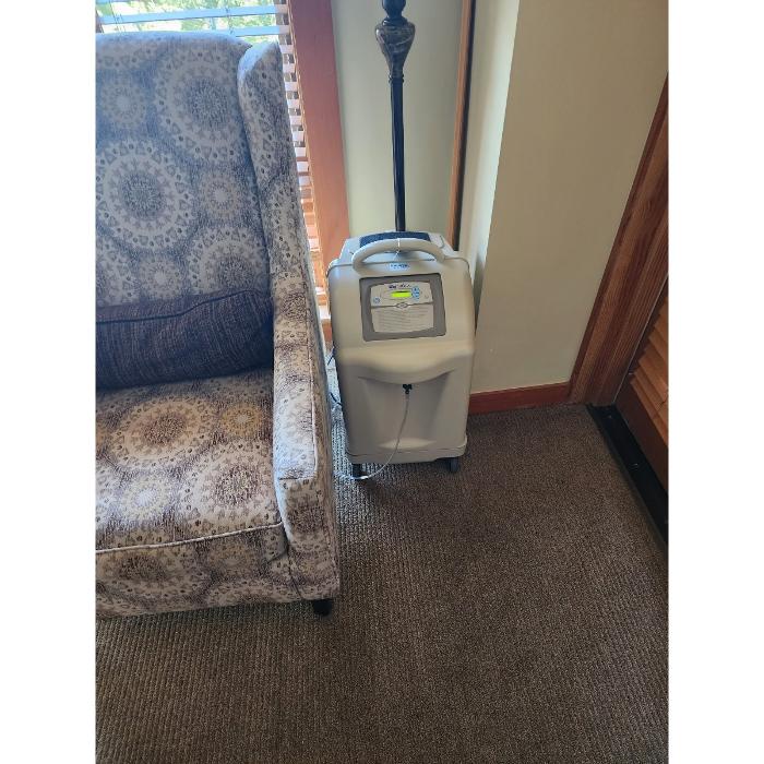 A compact oxygen concentrator set up indoors, showing the kind of rental equipment delivered for in-room use at high-altitude destinations.