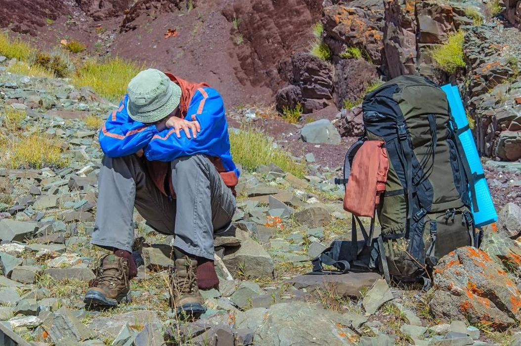 Two people trekking in a rugged alpine setting, representing travelers exploring high-altitude destinations where oxygen support may be helpful.