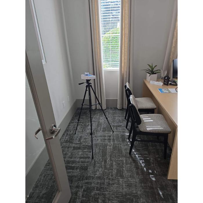 Monitoring equipment is positioned in a room near a window to collect indoor environmental data during a building health assessment.
