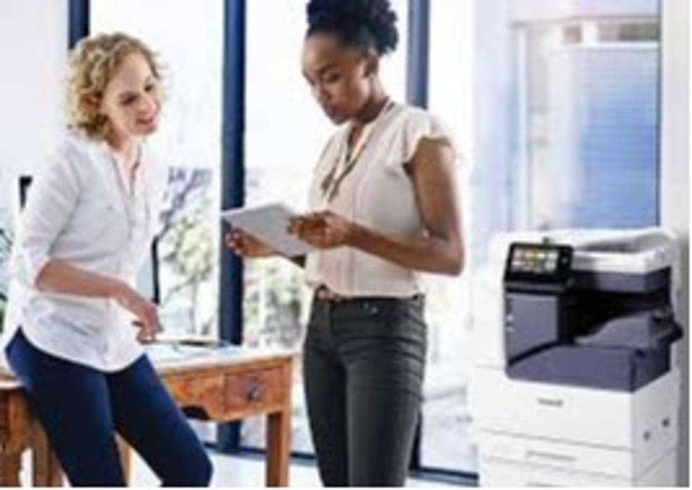 Two office professionals standing beside a Xerox multifunction printer, highlighting efficient document management, reliable printing solutions, and expert support provided by UIQ for today&rsquo;s business environments.