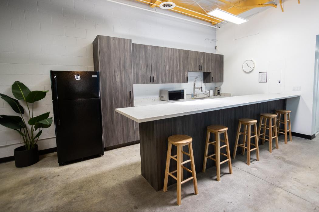 A clean, modern kitchen and dining space at Key Healthcare Adolescent Outpatient, complete with bright countertops and wooden bar stools, offering an inviting and home-like atmosphere for teens.