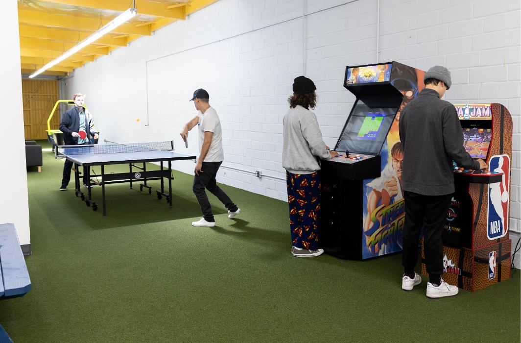 A lively recreation room at Key Healthcare Adolescent Outpatient, featuring a ping pong table, arcade games, and ample open space for teens to socialize and build positive peer relationships.