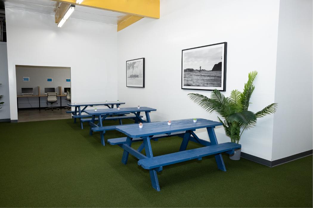 A bright, casual dining and multi-purpose area with blue picnic-style seating, providing a welcoming space for meals, group activities, and socializing at our teen treatment center.