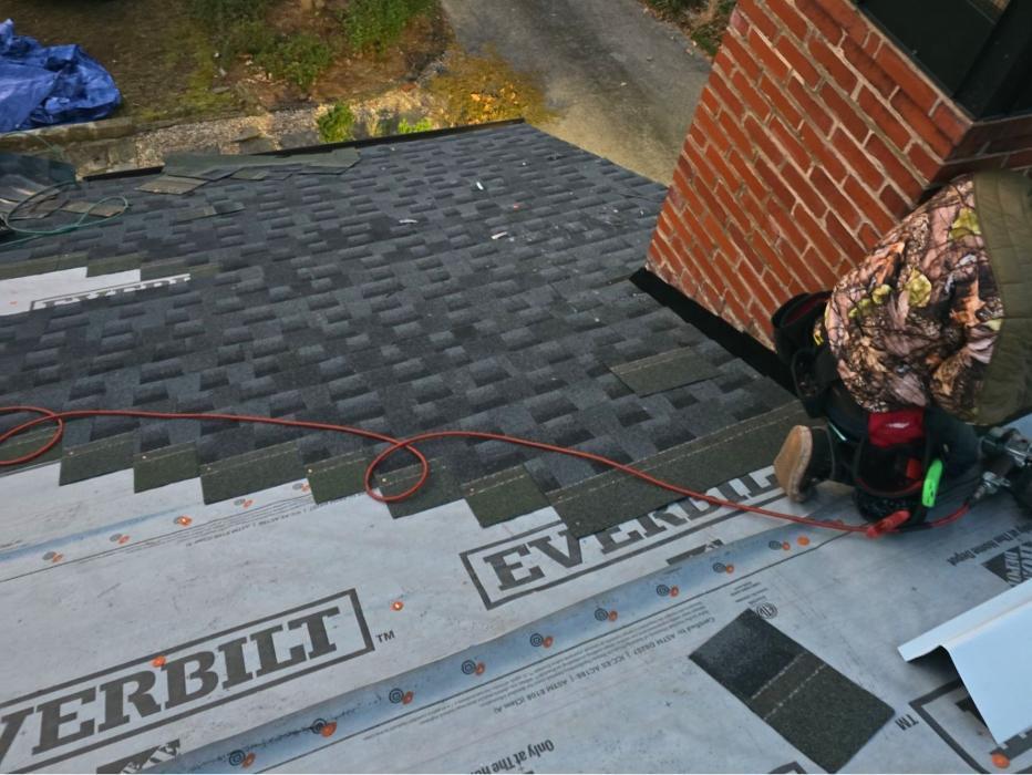 Active installation of new architectural shingles during a full residential roof replacement. Our crews ensure precise application for long-term weather protection.