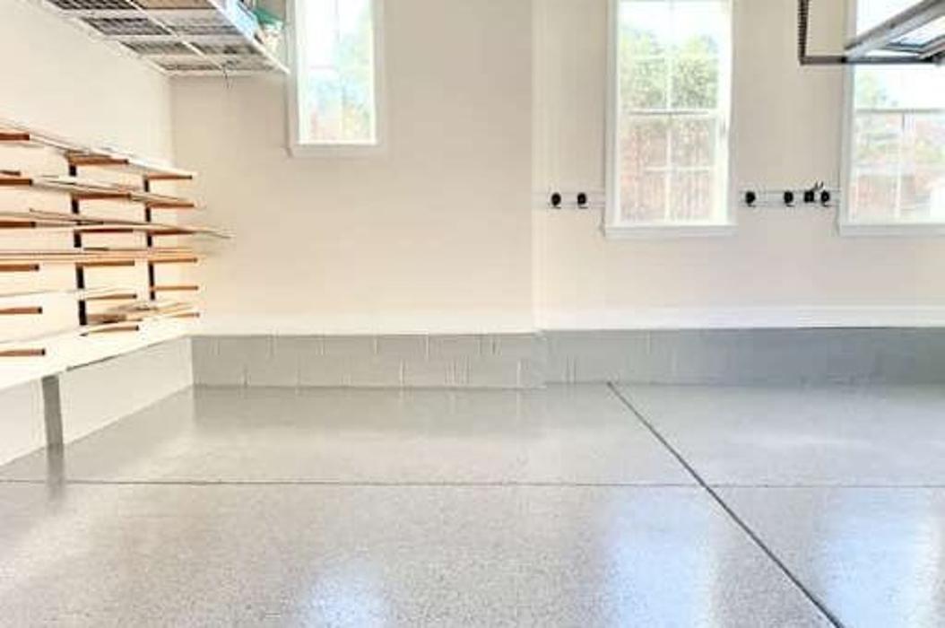 Clean epoxy-coated garage floor with storage shelving.