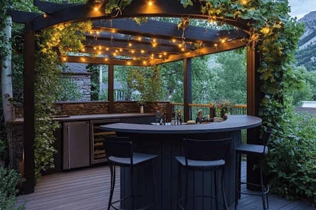Covered outdoor kitchen and bar with pergola lighting and mountain views.