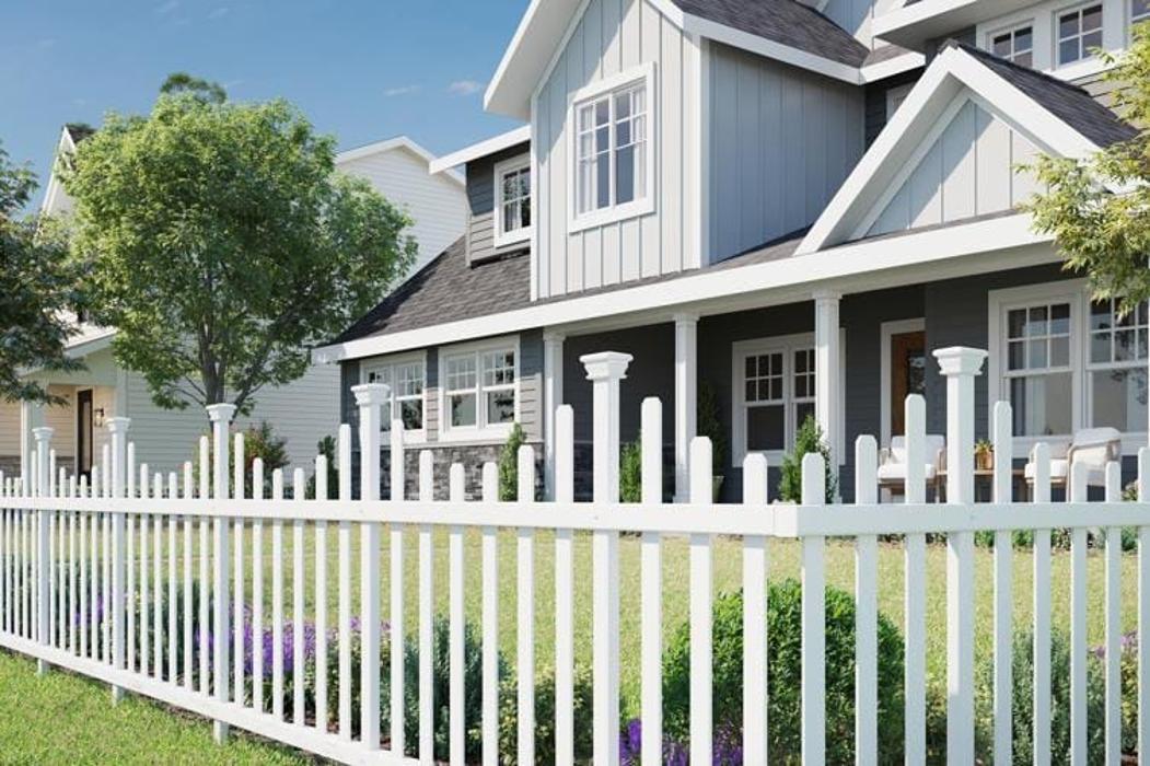 White picket fence in front of a modern farmhouse-style home.
