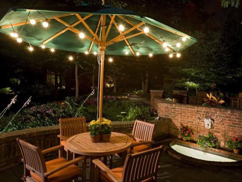 An inviting outdoor patio enhanced with overhead string lighting, creating a cozy and sophisticated setting for evening gatherings.

