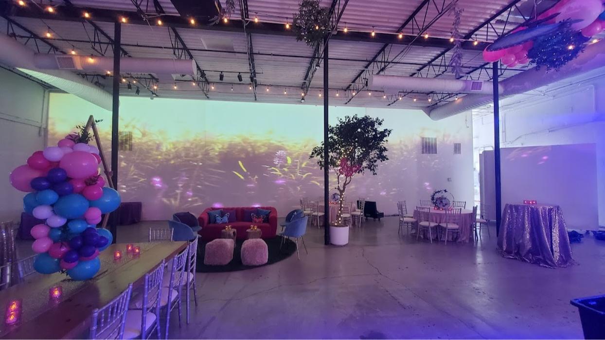 A modern event space enhanced with colorful ambient lighting, creating an elegant and immersive atmosphere for a special occasion.