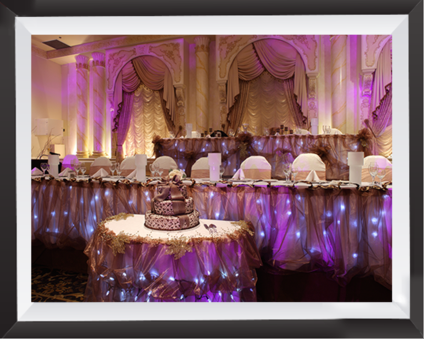 A beautifully decorated reception space with glowing accent lighting, elegant draping, and a warm ambiance for a memorable special event.