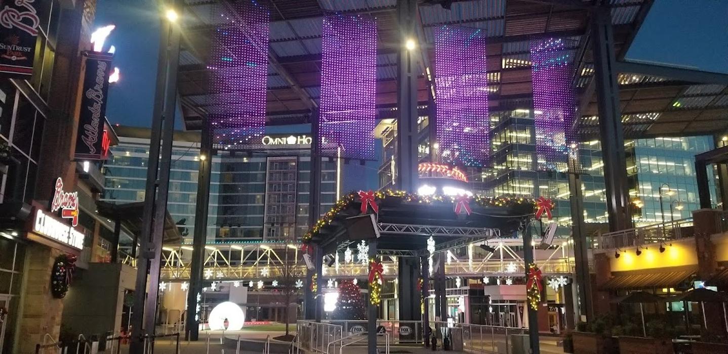 A city street transformed with suspended overhead lighting and vibrant illuminated d&eacute;cor, creating a dynamic and modern urban ambiance at night.