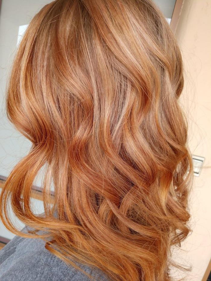 Rich copper red hair with glossy shine, soft cascading curls, and vibrant multidimensional tones for a bold elegant finish.