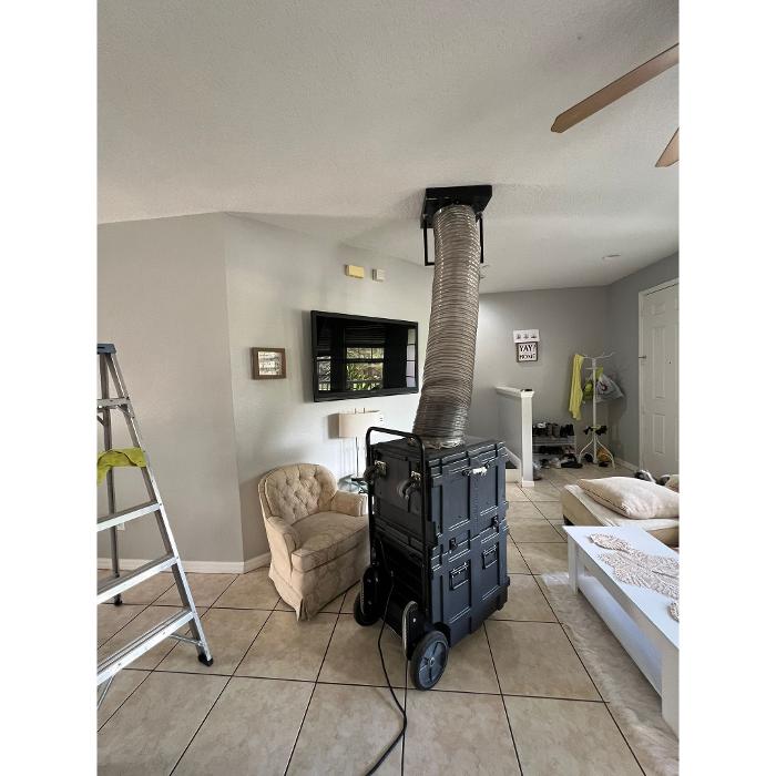 Professional duct cleaning equipment is positioned in a residential living space during an indoor air quality or HVAC cleaning service.