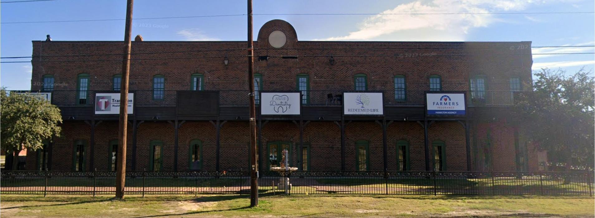 Exterior view of Redeemed Life Counseling in Argyle, TX, located in a professional brick building with clear signage and a welcoming, discreet setting for counseling services.