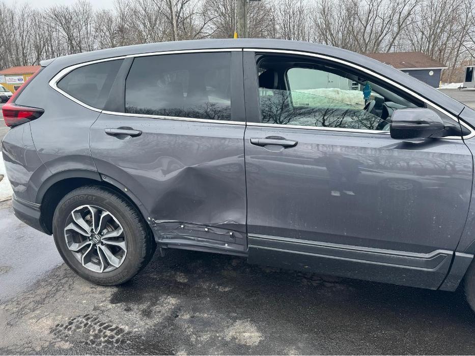 Side collision damage being assessed and repaired by auto body specialists.