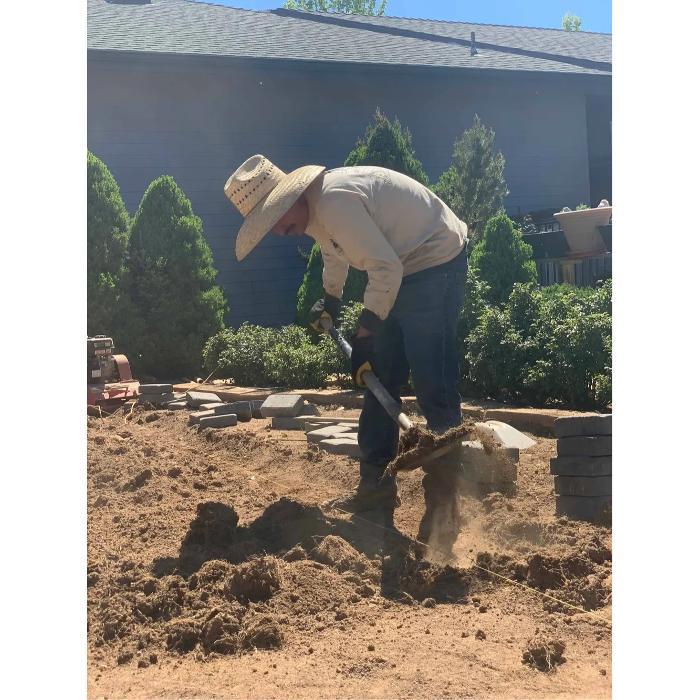 Landscape technician preparing soil and planting in a residential yard in Prescott Valley, Arizona