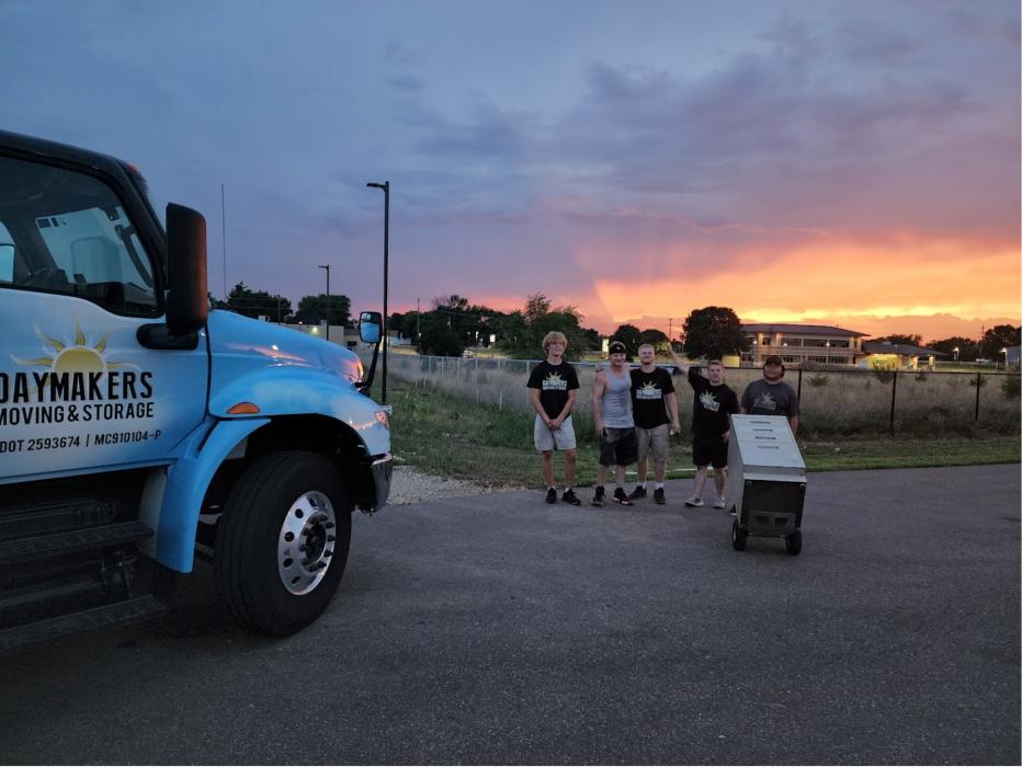 Daymakers Moving & Storage crew stands by their truck with equipment at sunset in Roseville, MN.
