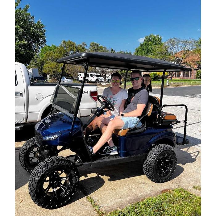 People smiling in a blue golf cart from Golf Carts of ATX in Austin, Texas.