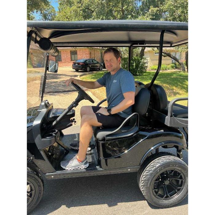 Man seated in a black golf cart from Golf Carts of ATX in Austin, Texas.