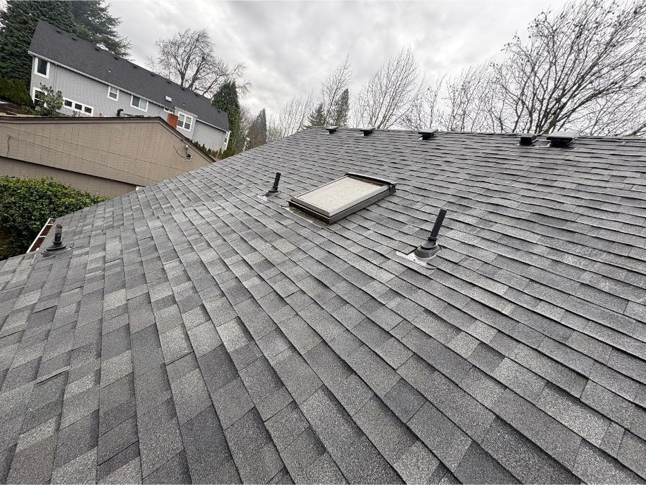 Roof inspection view of asphalt shingle roofing in Portland OR with skylight and ventilation features by KVN Portland Roofing