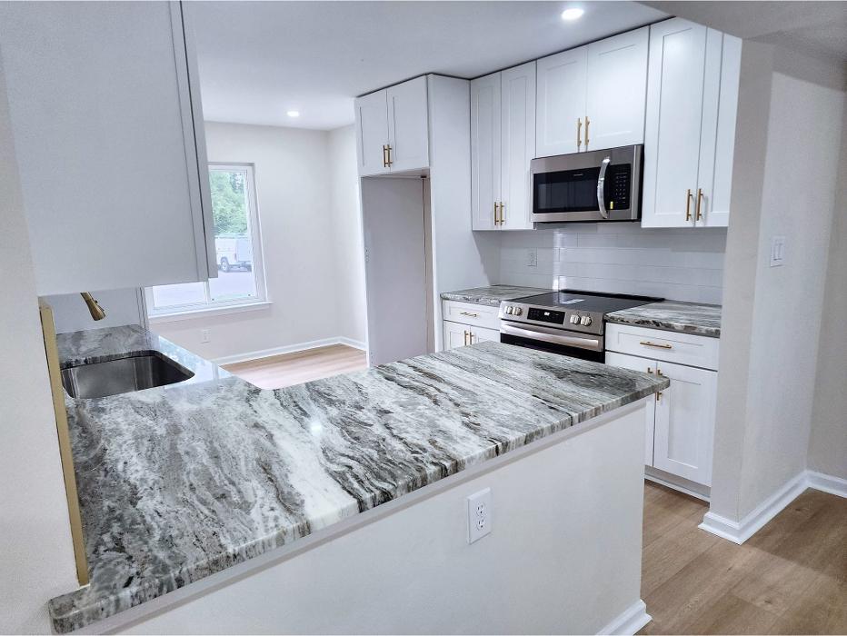 Kitchen remodeling project featuring white cabinets, updated countertops, modern finishes, and improved layout by Divine Touch Home Improvements.
