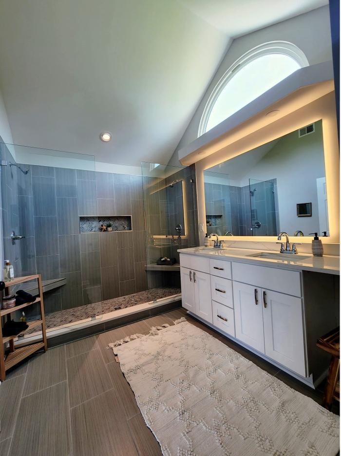 Bathroom remodeling project with updated vanity, lighting, flooring, and shower area for a cleaner, more comfortable space.