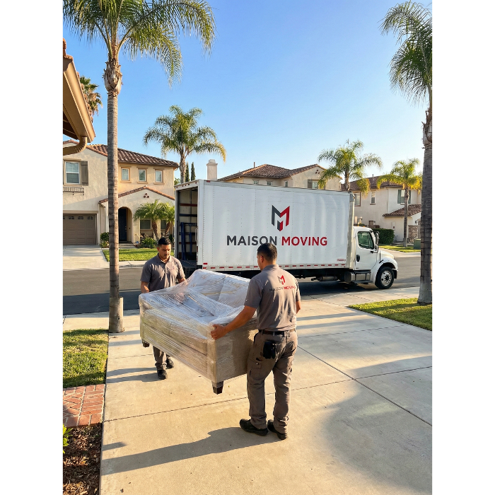 Maison Moving & Storage movers carrying a wrapped sofa from a Tustin, California home.