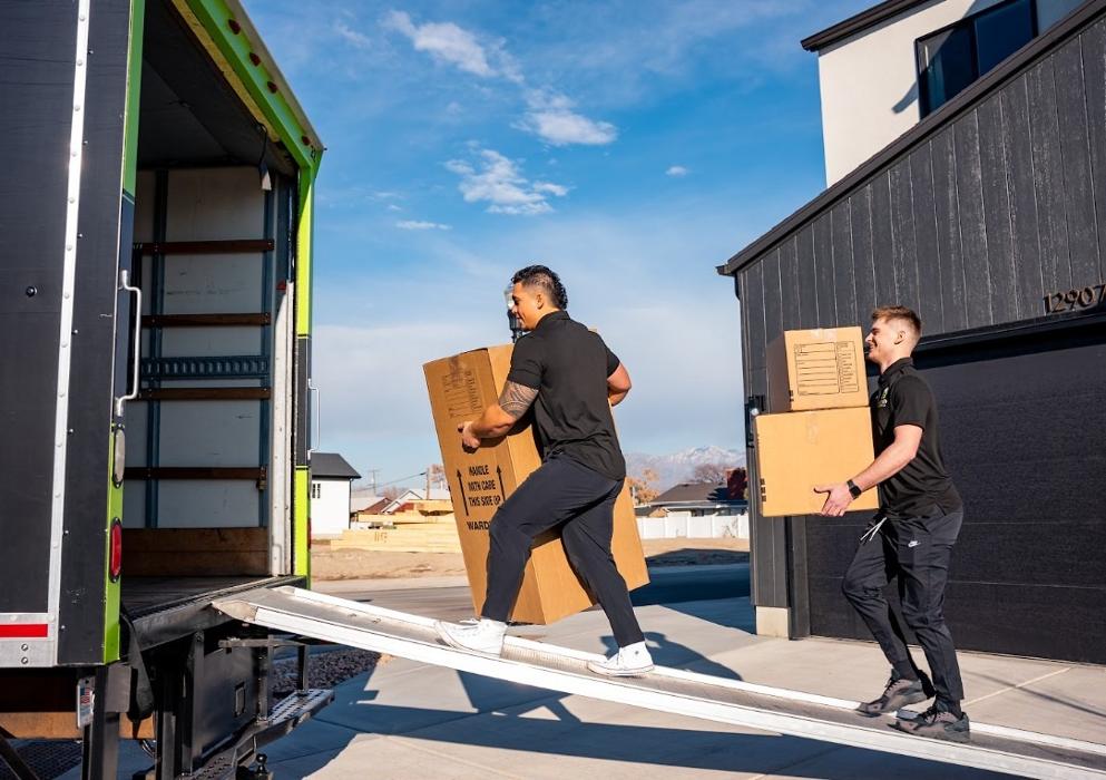 Best of Utah movers loading cardboard boxes into a moving truck at a Salt Lake City home