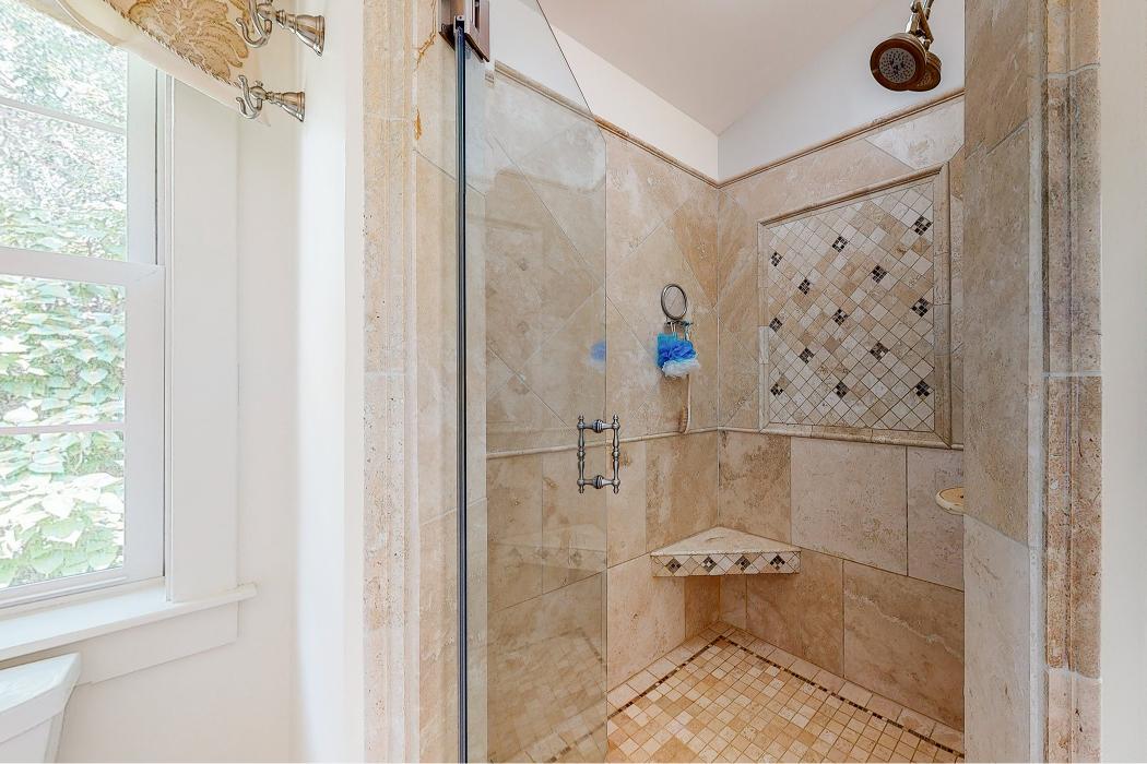 Custom tile shower with glass enclosure and bench seat