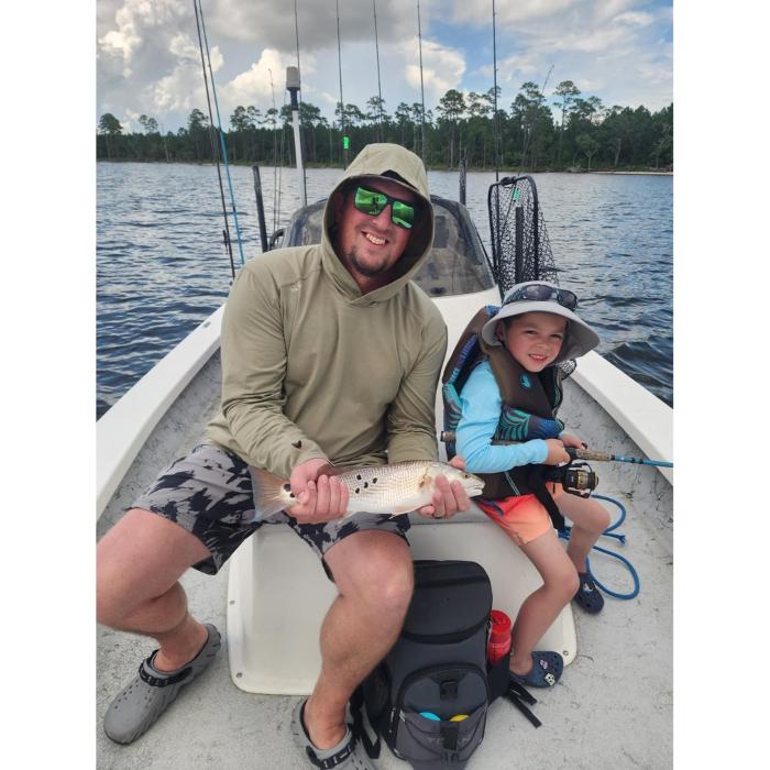 Father and child enjoying a Navarre fishing charter with Showintail Inshore Charters