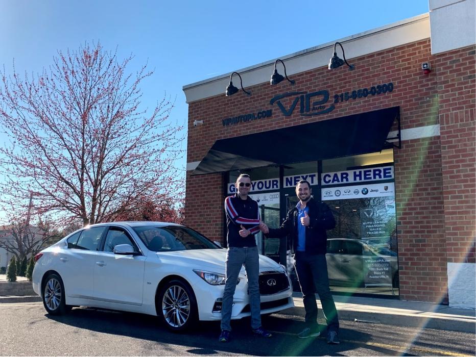 Customer receiving a white car outside VIP Auto PA in Feasterville-Trevose, Pennsylvania.