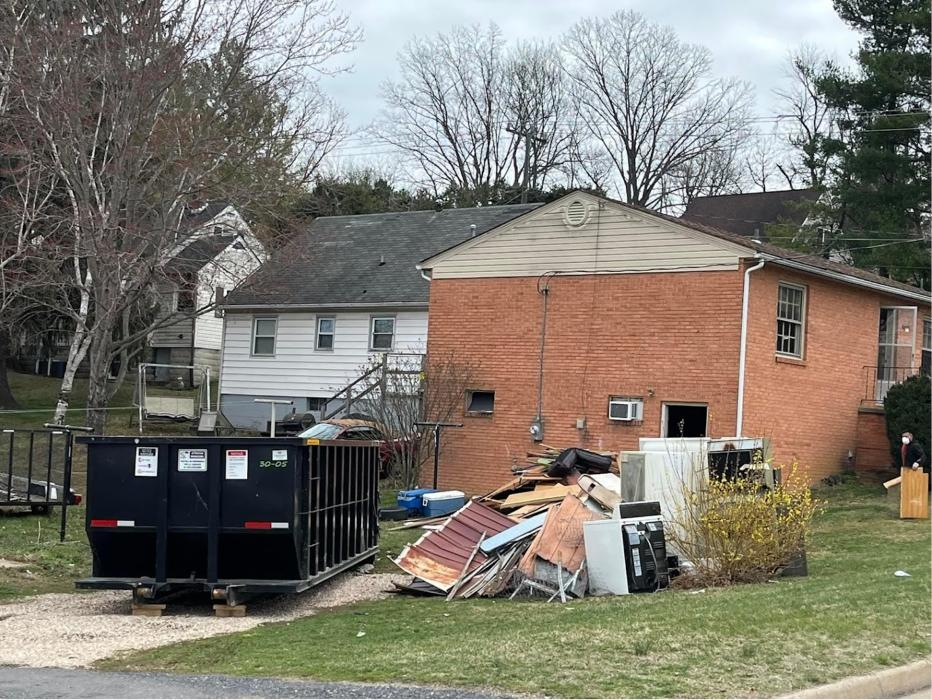 EZ Dumpster Services rental dumpster beside a debris pile at a Staunton, Virginia property.