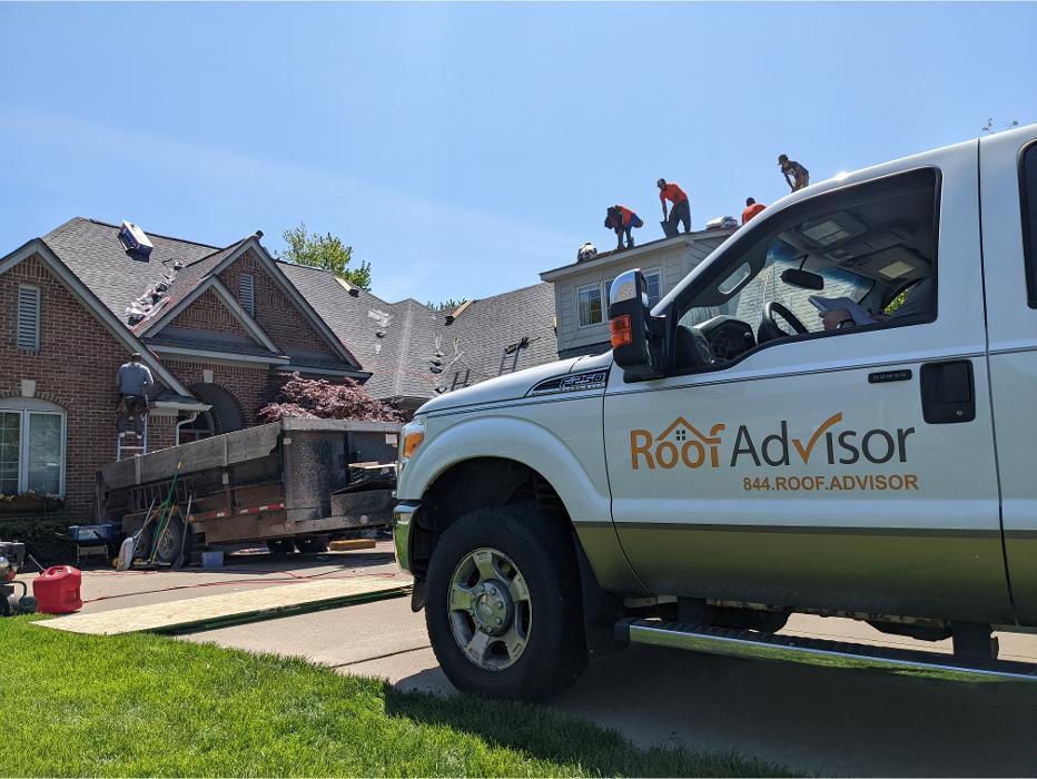 RoofAdvisor branded truck on a job site during roof installation