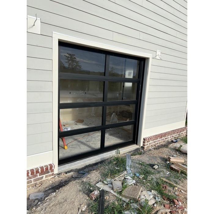 Sleek black-frame glass garage door installed on a home in the Atlanta area — Hawk Garage Doors